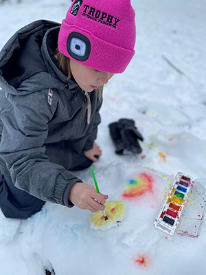 Student painting on snow