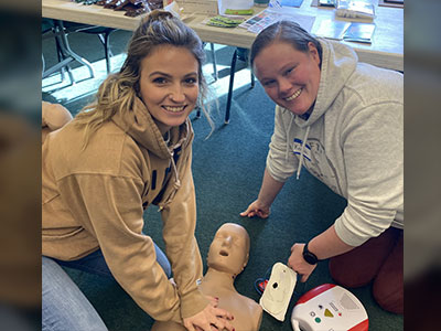 Two staff members doing CPR training